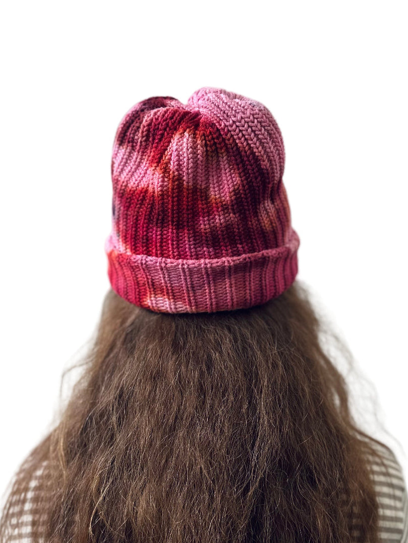 Person wearing a pink tie dye chunky knit beanie