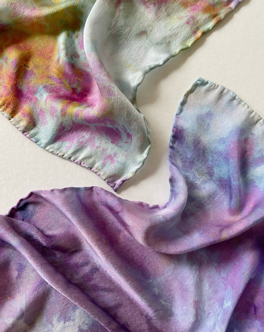 Hand dyed silk scarf with a floral pattern in multiple colors including purple, pink, and blue.