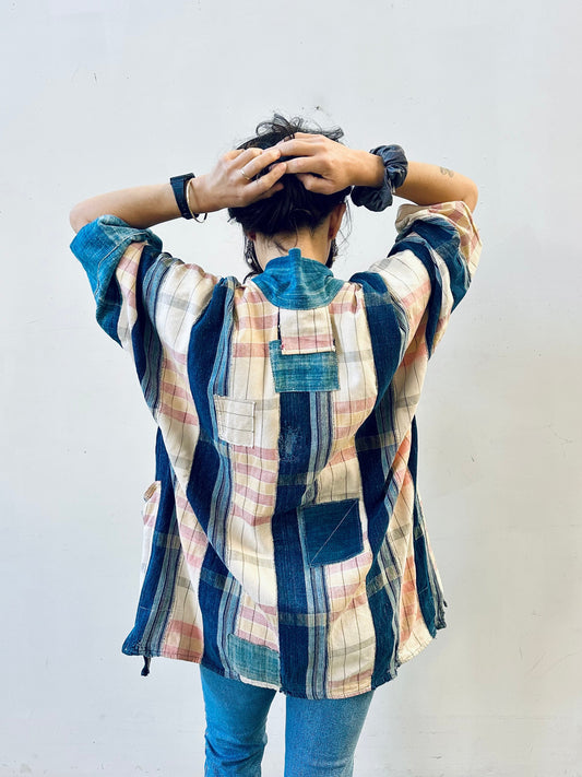 Person wearing a patchwork shirt with a plain background