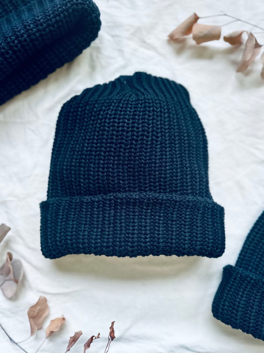 chunky knit black beanie hat on white cloth