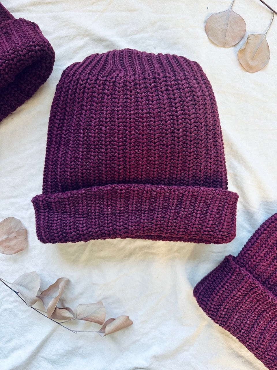 burgundy chunky knit beanie on white background